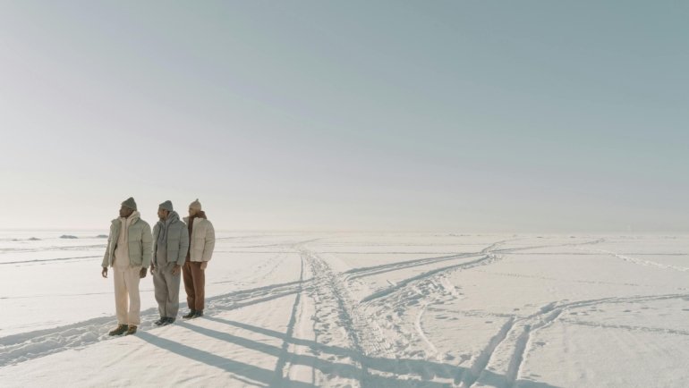 A stylish modern adventurer with a premium backpack overlooks a majestic natural landscape, symbolizing Trevor Morrow's approved authentic and adventurous travel.