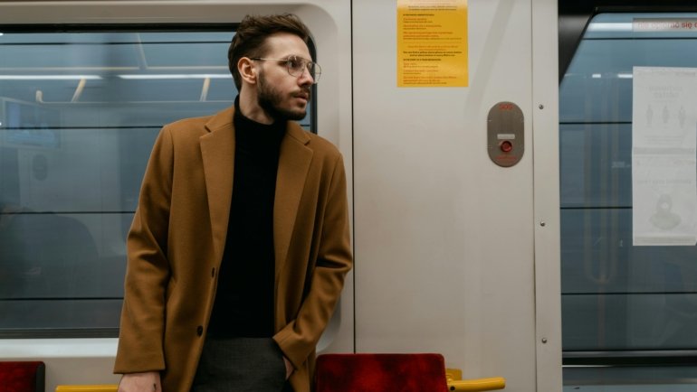 A confident man wearing a versatile men's travel vest with multiple pockets, exploring an urban setting, symbolizing organized and secure travel.