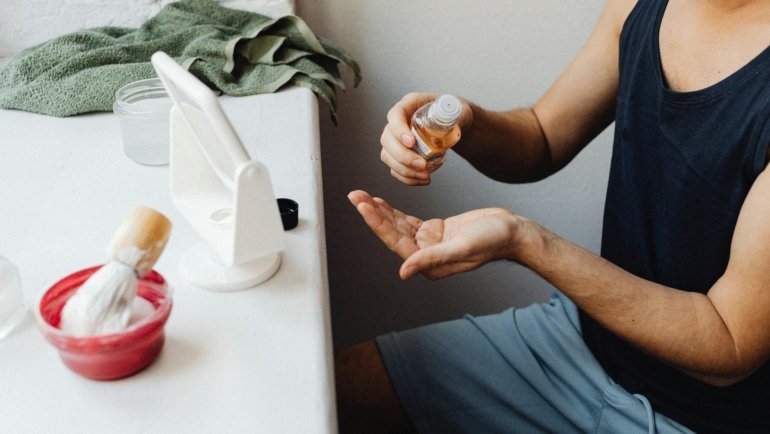 Compact travel shaving cream and razor in a hotel bathroom, illustrating essential men's grooming for a comfortable, TSA-compliant shave while traveling.