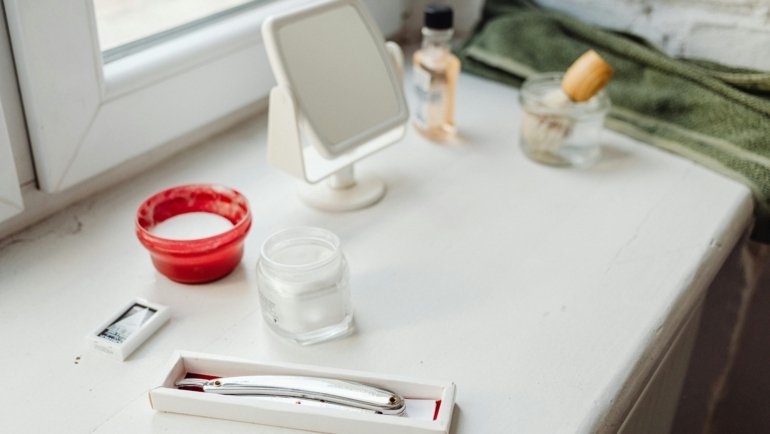 A stylish and organized men's travel kit (dopp kit) open, showcasing travel-sized grooming essentials like toothpaste, razor, and skincare products, ideal for efficient packing and fresh travel.