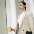 Customized stainless steel travel cup with a unique design, held by a person during an urban commute, symbolizing sustainable living and personal style.