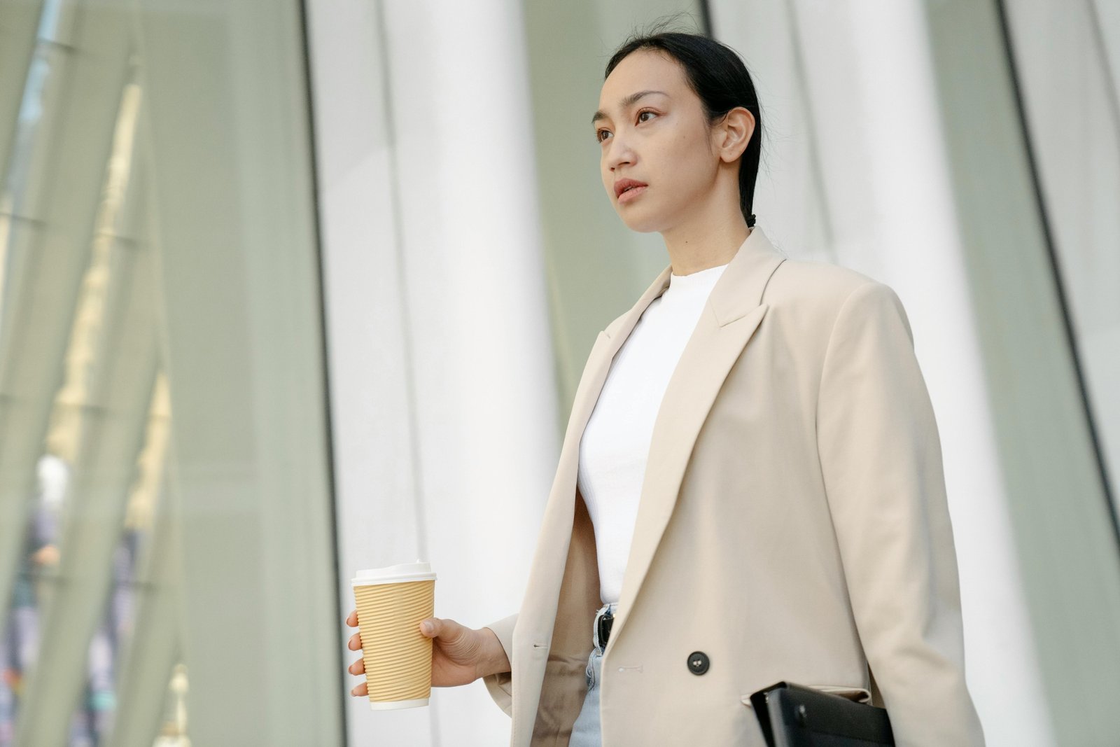 Customized stainless steel travel cup with a unique design, held by a person during an urban commute, symbolizing sustainable living and personal style.