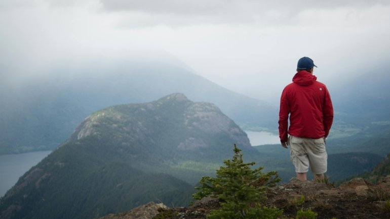 Adventurous traveler contemplating a vast, inspiring landscape, evoking wanderlust and the spirit of short travel quotes and personal journeys.