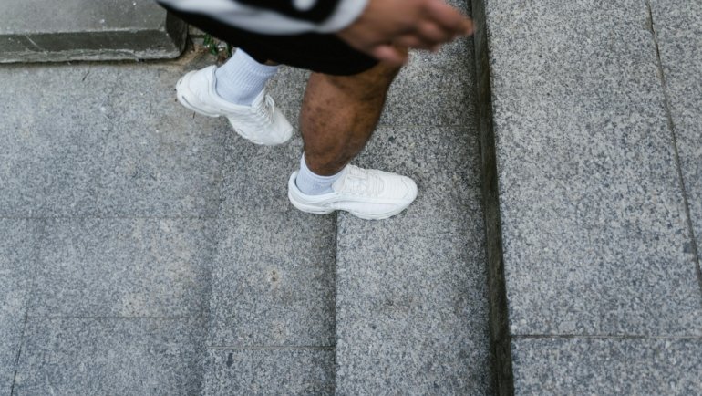 Person wearing comfortable and versatile travel shoes while walking and exploring a vibrant city or natural landscape, emphasizing readiness for adventure.