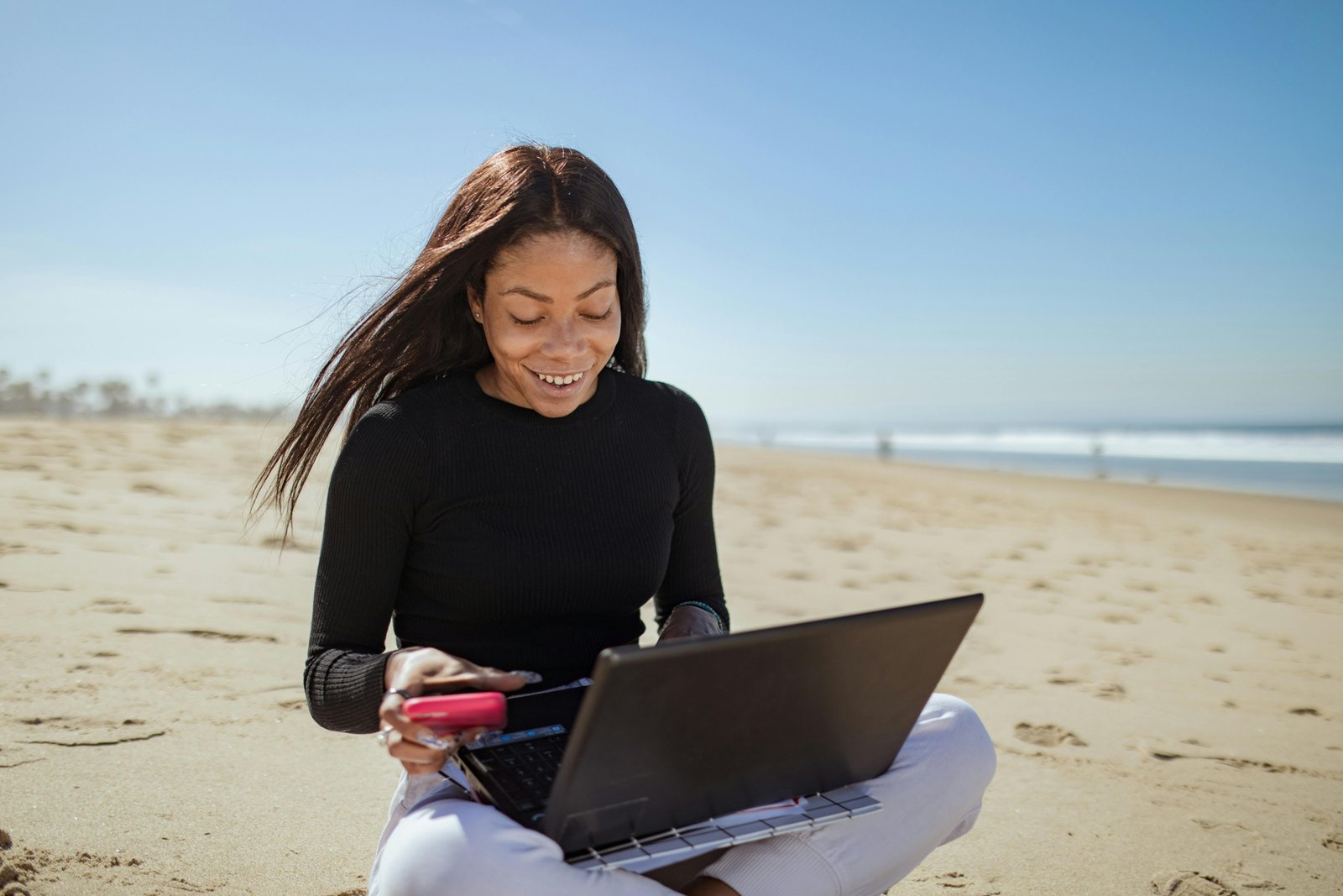 Happy traveler using Travel Vids XYZ to easily edit a stunning travel video on their laptop or mobile, perfect for sharing memorable adventure stories.