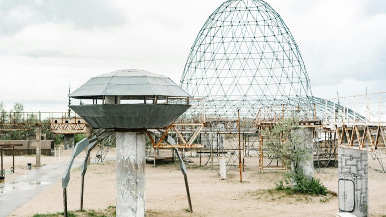 The Space Age Travel Center in Gila Bend, Arizona, an iconic retro-futuristic roadside attraction with its UFO-shaped Googie architecture and classic diner, set against a desert landscape.