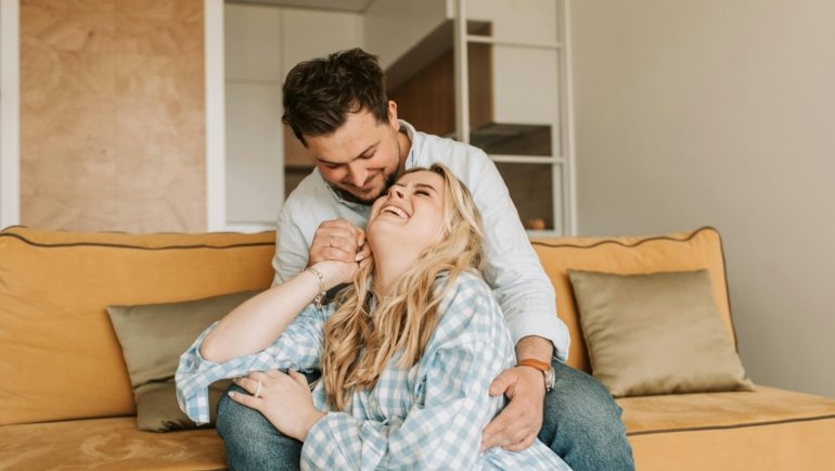 Happy pregnant couple relaxing on a babymoon vacation with peace of mind, thanks to specialized travel insurance for pregnancy.