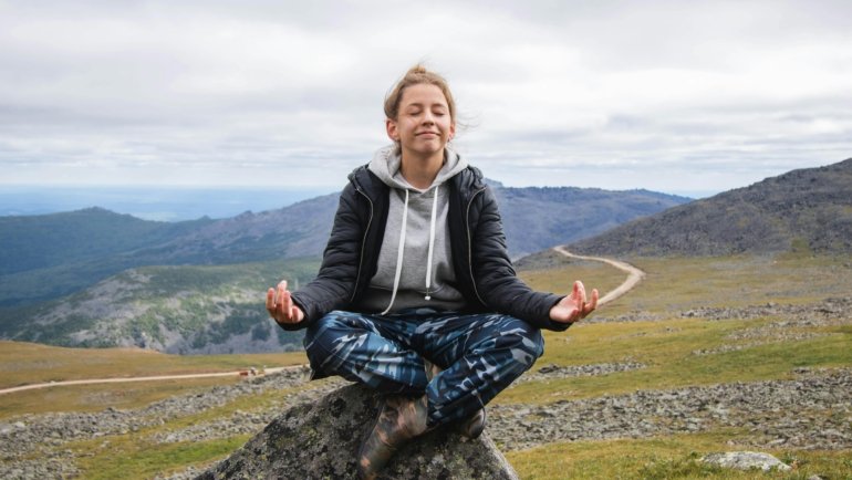 Mindful traveler contemplating a serene landscape, symbolizing personal growth and healing through travel therapy for mental well-being.