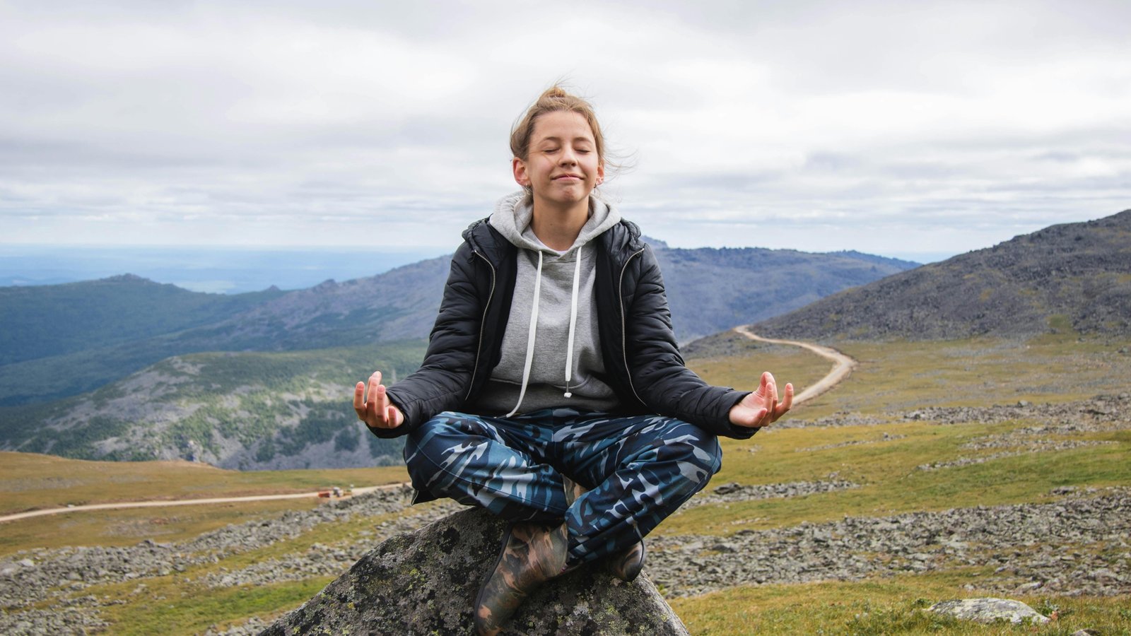 Mindful traveler contemplating a serene landscape, symbolizing personal growth and healing through travel therapy for mental well-being.