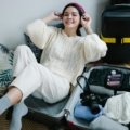 Thoughtful presents for a traveler: close-up of hands packing a suitcase with essential travel gifts such as packing cubes, a universal adapter, and a portable power bank, ready for an adventure.