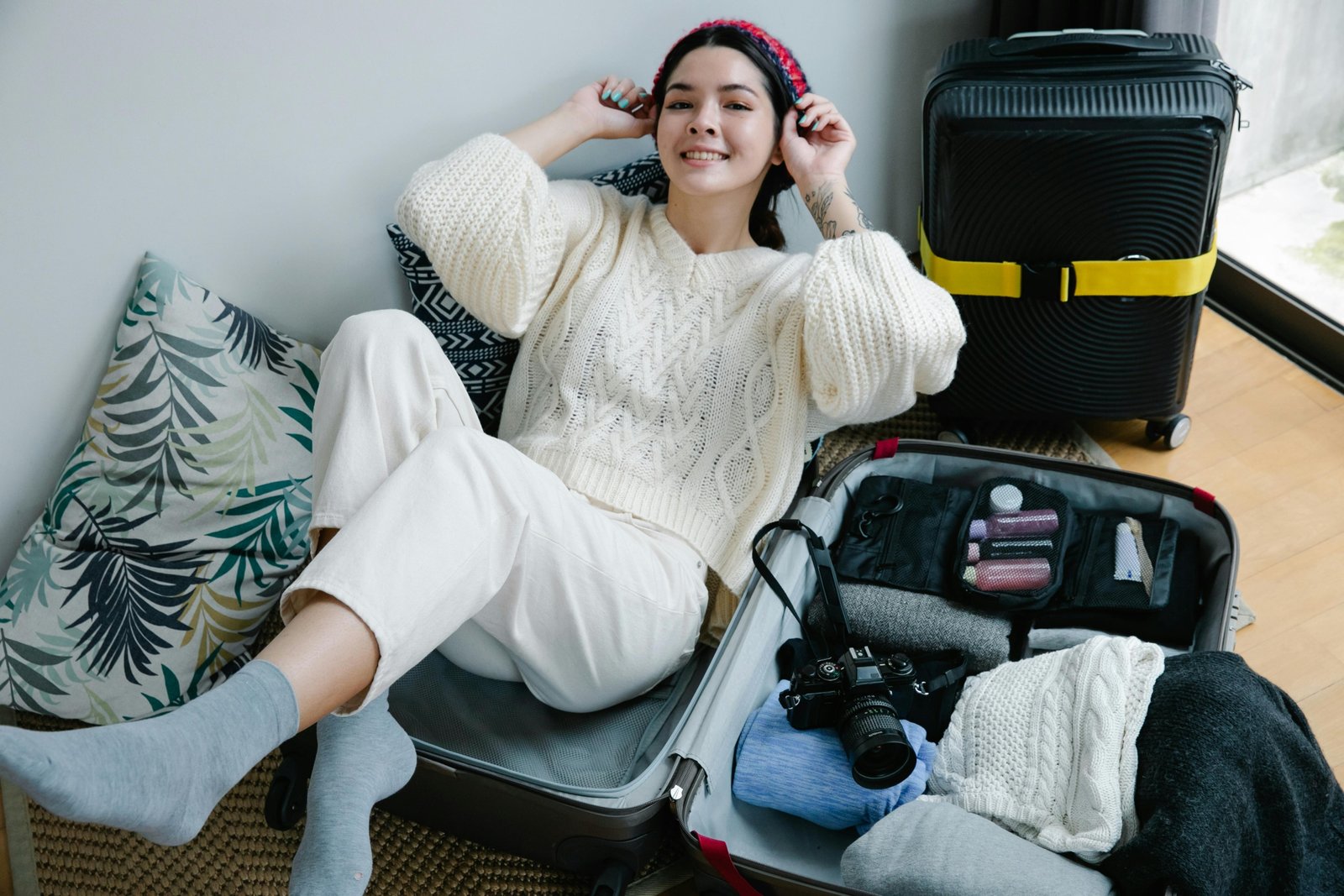 Thoughtful presents for a traveler: close-up of hands packing a suitcase with essential travel gifts such as packing cubes, a universal adapter, and a portable power bank, ready for an adventure.
