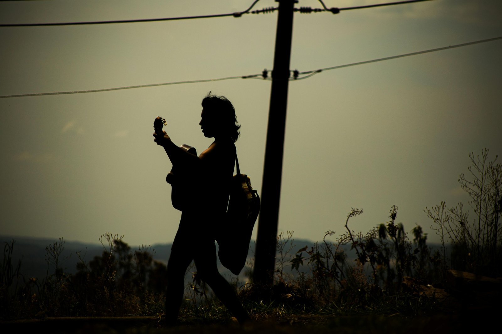 Musician playing a portable electric travel guitar, showcasing the convenience and inspiration for creating music while exploring new destinations.
