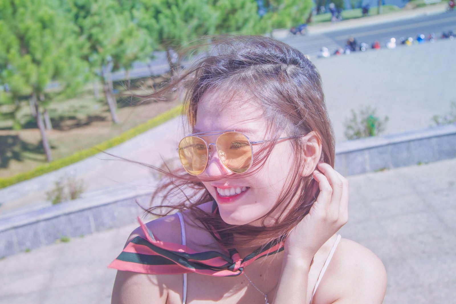 Happy woman applying travel size hair styling mousse for effortless, perfect hair while traveling, ideal for carry-on and all hair types.
