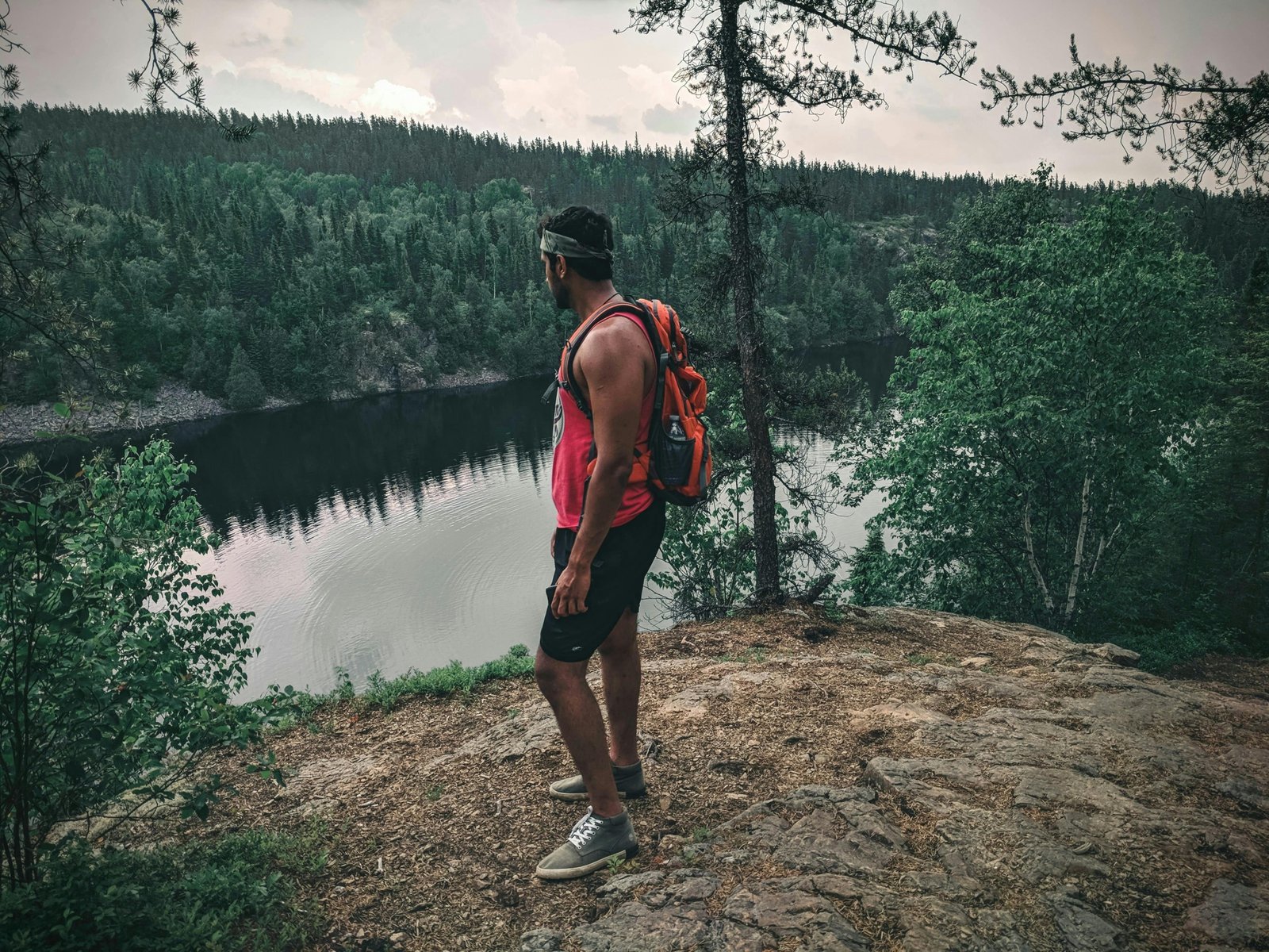 A solo traveler with a light backpack stands on a scenic overlook, symbolizing the freedom and thrill of finding last-minute deals for spontaneous solo travel adventures.