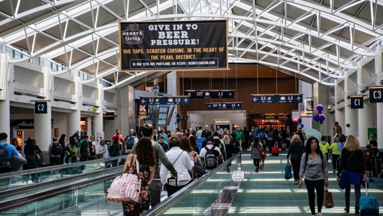 Busy Dubai International Airport (DXB) terminal reflecting the February travel spike with numerous passengers and modern architecture.