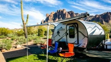 Lance travel trailer in a scenic natural landscape, symbolizing lightweight design, four-season comfort, and adventurous outdoor living.