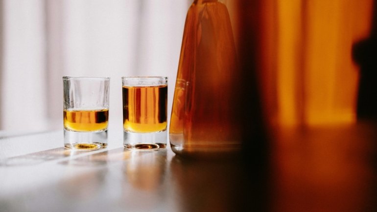 Traveler Bourbon whiskey bottle and glass, showcasing the rich amber liquid and inviting smooth tasting profile of this approachable premium collaboration by Chris Stapleton and Buffalo Trace.