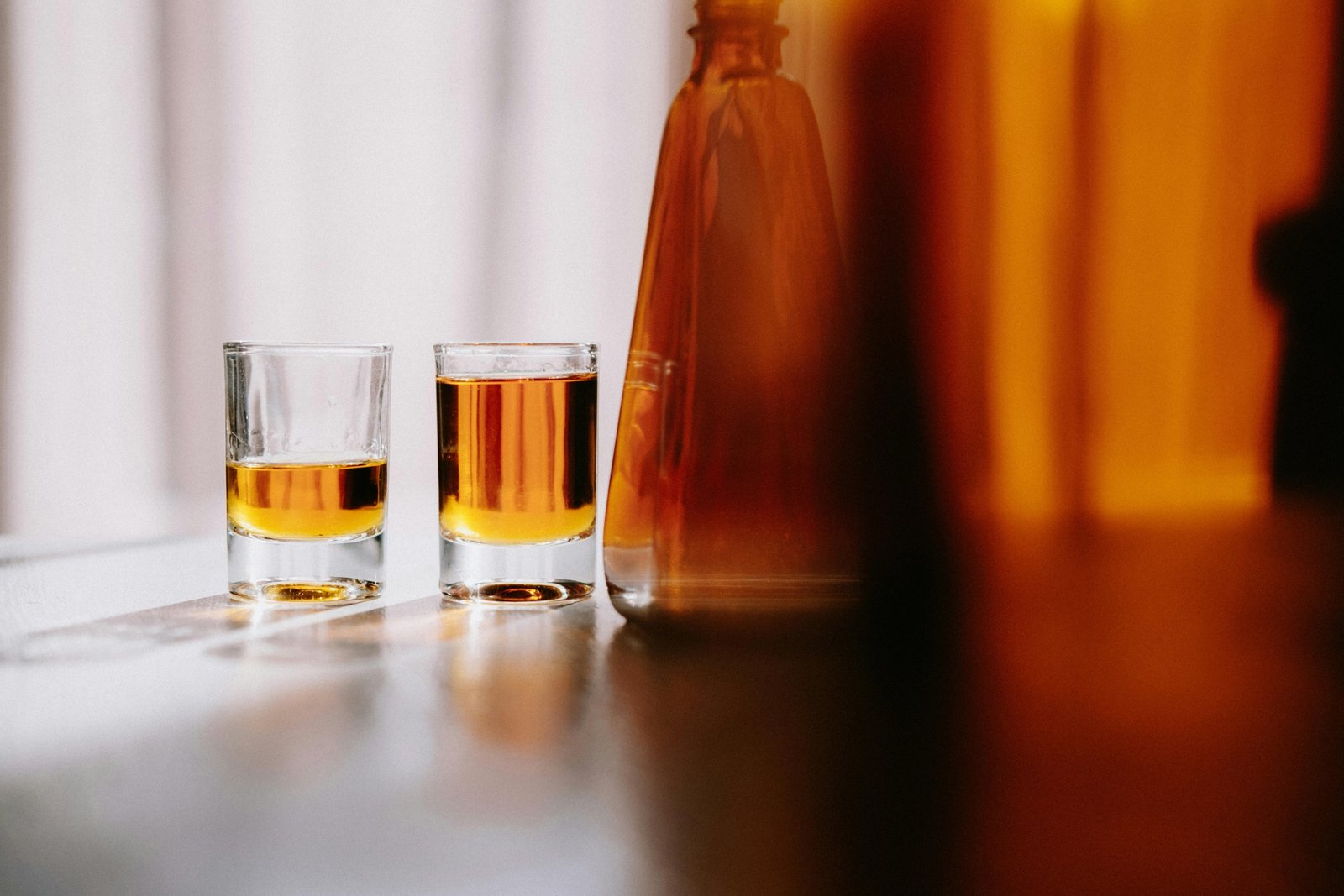 Traveler Bourbon whiskey bottle and glass, showcasing the rich amber liquid and inviting smooth tasting profile of this approachable premium collaboration by Chris Stapleton and Buffalo Trace.