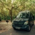 Custom Mercedes Sprinter travel van conversion for adventure and van life, parked in a scenic natural landscape, embodying freedom and off-grid living.