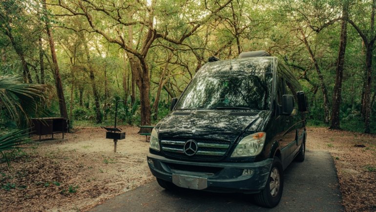 Custom Mercedes Sprinter travel van conversion for adventure and van life, parked in a scenic natural landscape, embodying freedom and off-grid living.