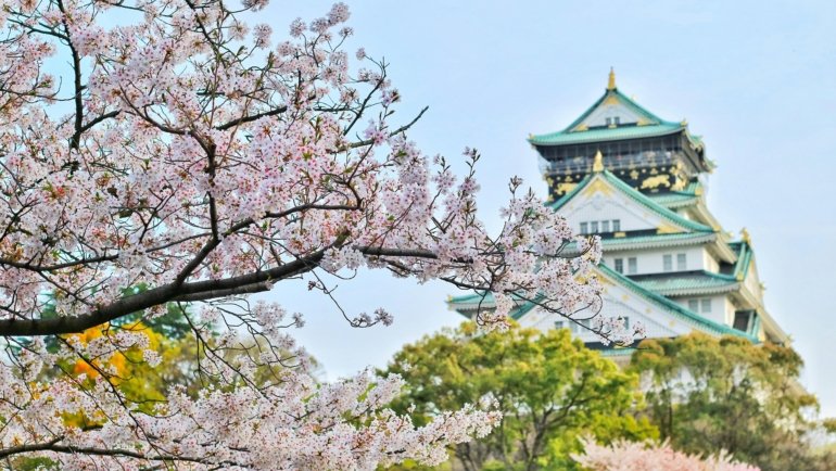 Japan 2-week travel itinerary featuring iconic landmarks blending ancient traditions and modern cities, such as a temple against a futuristic skyline or Mount Fuji.