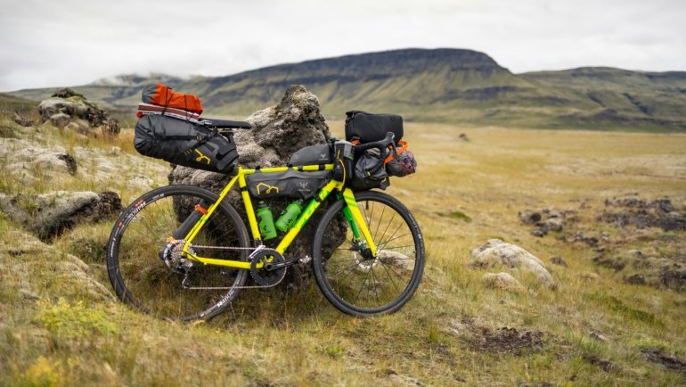 A cyclist effortlessly pulling a durable bike travel case with wheels through an airport terminal, highlighting secure bicycle transport for an adventure trip.