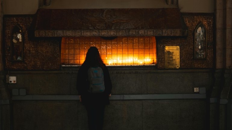 Hands clasped in peaceful prayer by a traveler, symbolizing divine protection, comfort, and safety for a serene journey.