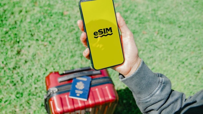 Happy traveler using smartphone in an exciting foreign city, symbolizing seamless global connectivity with a reliable travel contact solution like an eSIM or international SIM card.