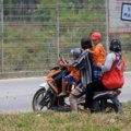 Child passenger safely riding a motorcycle with an adult, both wearing a reflective ride safe travel vest for secure family adventure.