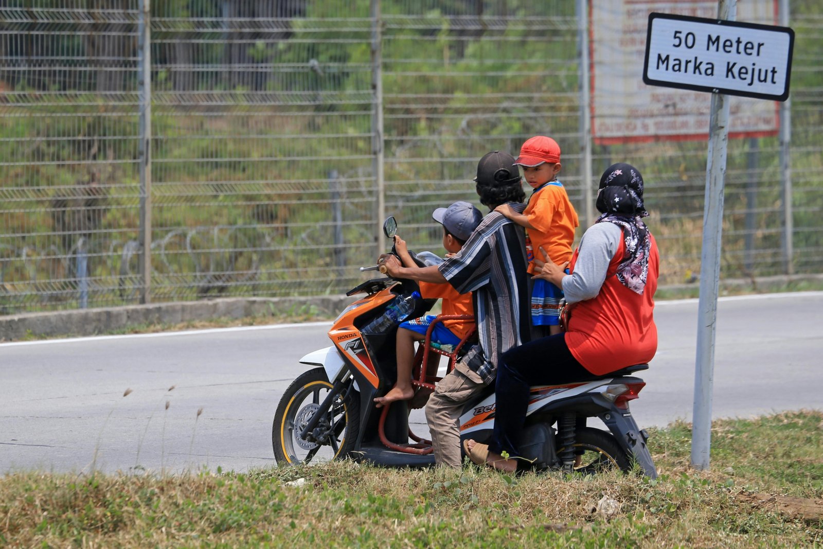 Child passenger safely riding a motorcycle with an adult, both wearing a reflective ride safe travel vest for secure family adventure.