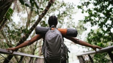 Stylish petite woman confidently packing a versatile travel capsule wardrobe into a suitcase, showcasing perfectly fitted clothing designed for comfort and chic adventures.