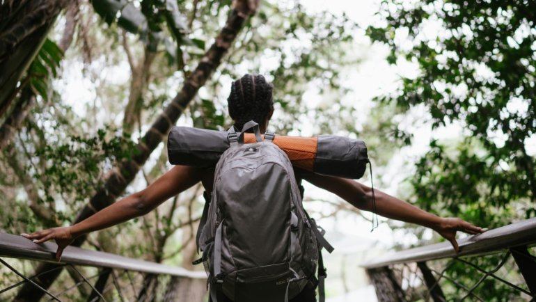 Stylish petite woman confidently packing a versatile travel capsule wardrobe into a suitcase, showcasing perfectly fitted clothing designed for comfort and chic adventures.