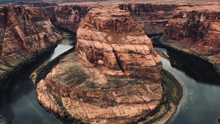 Breathtaking panoramic view of the Grand Canyon's vast, colorful landscape under a clear sky, representing ideal conditions for a visit during spring or fall.