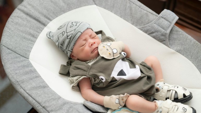 Baby sleeping peacefully in a portable infant travel bassinet, illustrating safe and comfortable sleep solutions for families on the go.