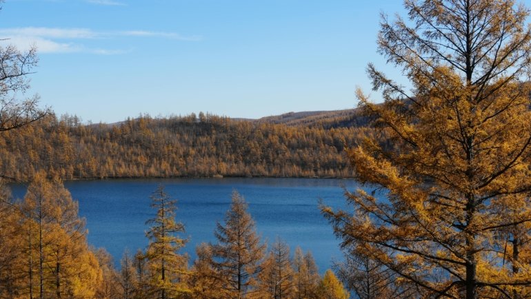 Scenic autumn landscape with vibrant fall foliage and golden light, illustrating the best October travel destinations for peaceful and beautiful getaways.