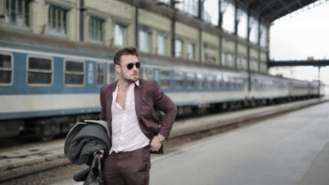 Mystery Ranch Mission Rover travel convertible bag in backpack, shoulder bag, or briefcase mode, used by a traveler in an urban setting for versatile and organized one-bag travel.