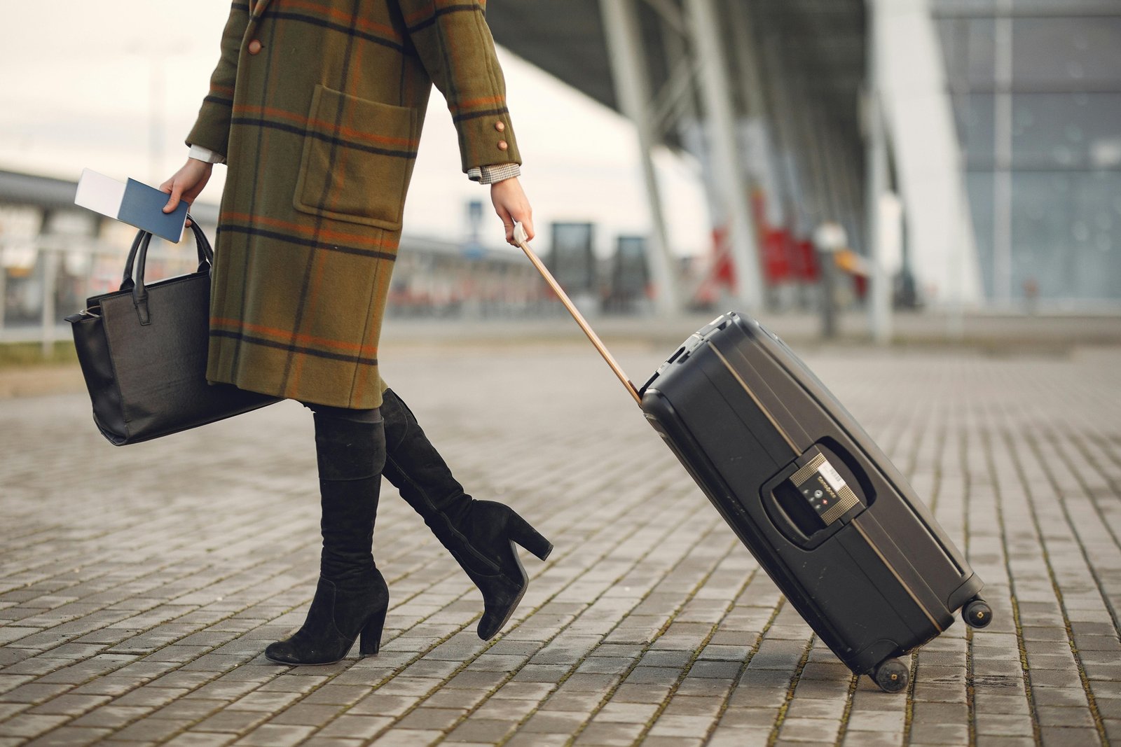 Stylish woman confidently walking through a modern airport terminal with a Beis Travel Tote, highlighting its elegant design and practical features as an organized carry-on bag.