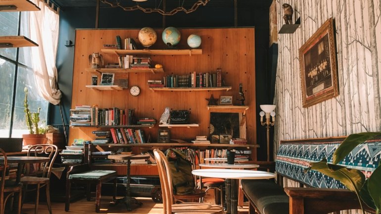 Diverse travelers relaxing and socializing in a welcoming common room of an authentic traveller's inn, emphasizing community and affordable lodging.