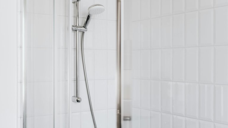 Modern travel trailer shower toilet combo wet bath interior in a compact RV, featuring an integrated shower and toilet for optimal space-saving design.