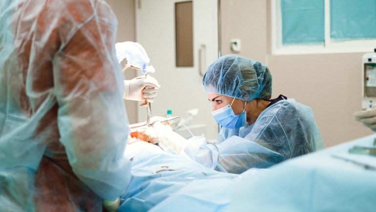 Registered Nurse First Assistant (RNFA) in scrubs working in an operating room, symbolizing high-paying travel nurse jobs, professional growth, and career flexibility for surgical nursing.