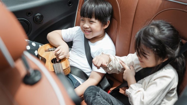 Happy family with toddler and lightweight travel car seat at airport, emphasizing safe and hassle-free journeys.