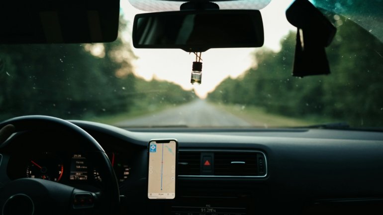 A stunning South Dakota landscape featuring a car on a scenic road, representing safe and planned travel through the state's diverse environment, emphasizing preparedness for an adventurous road trip.