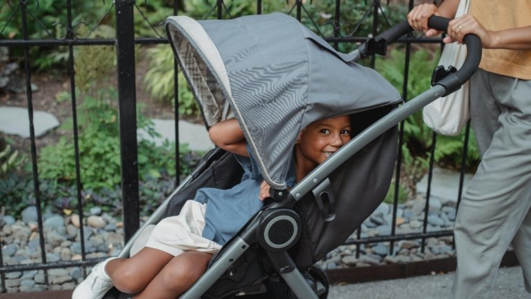 Happy family traveling with a lightweight, compact stroller at an airport, showcasing the convenience and ease of modern travel with children.