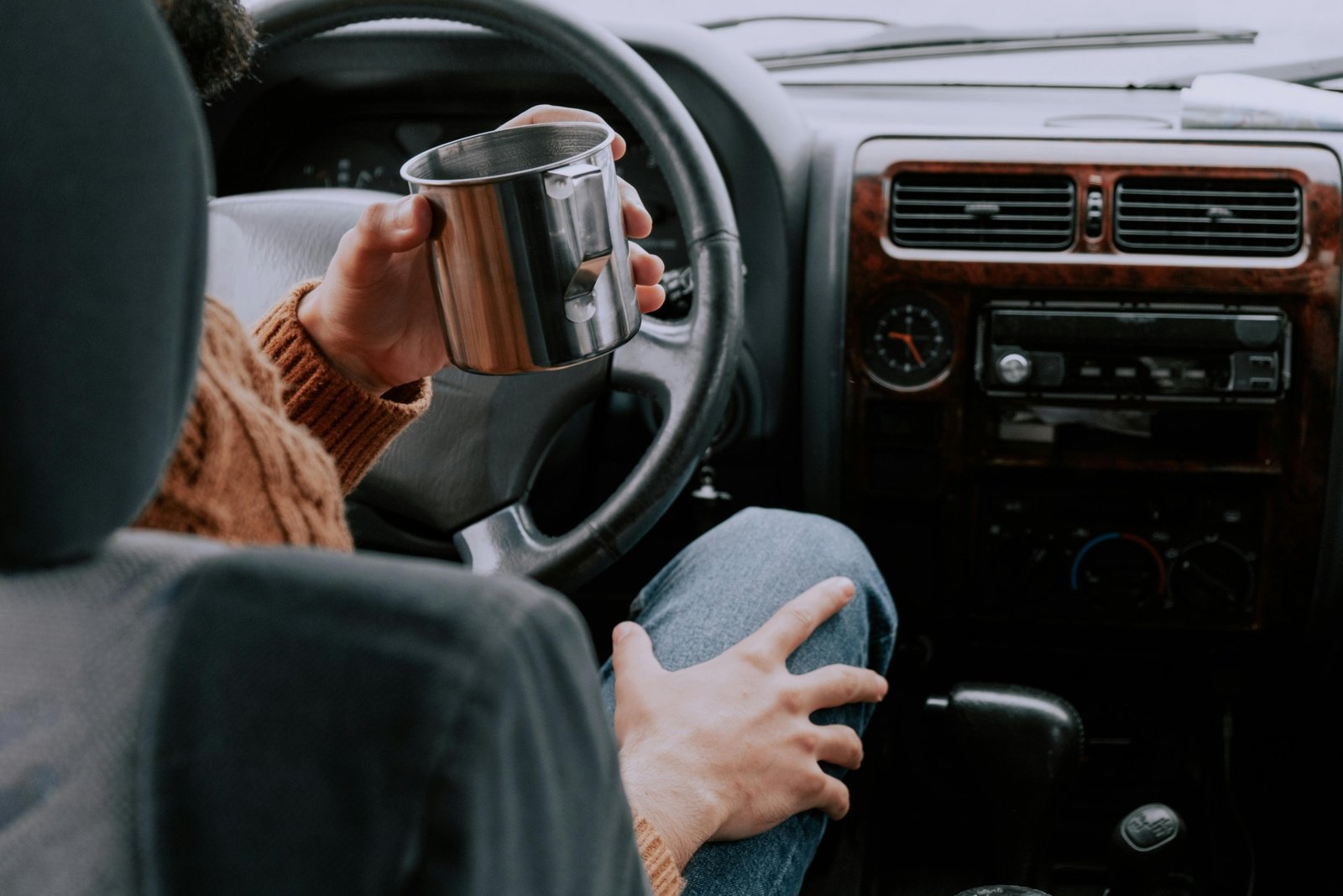Person enjoying perfectly hot coffee from a sleek smart heated travel mug during their morning commute, highlighting convenience and advanced beverage technology.
