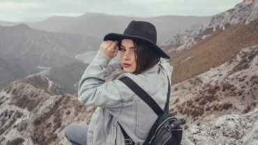 Empowered solo female traveler with a backpack exploring a vibrant destination, symbolizing freedom, self-discovery, and the 'creativeculturetribe' movement in solo female travel.