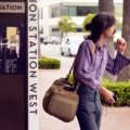 A traveler confidently navigating a bustling city street with a modern anti-theft travel bag, symbolizing secure valuables and peace of mind during their journey.
