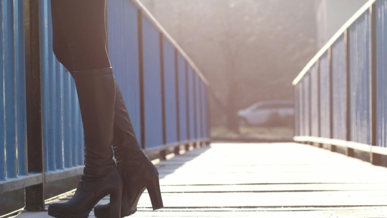 Stylish and comfortable walking shoes navigating a cobblestone street in a picturesque European city, highlighting ideal footwear for Europe travel.