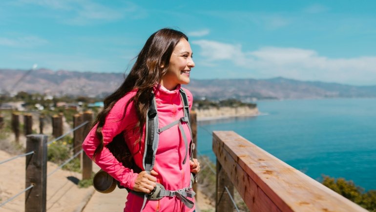 Best female travel backpack: A smiling woman effortlessly carrying a perfectly fitted women's travel pack, ready for her next adventure.