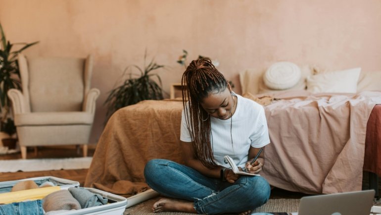 A person planning a trip with a map, passport, and notebook, symbolizing the ease of learning to talk about past travels in French with 'voyager' and the passé composé.