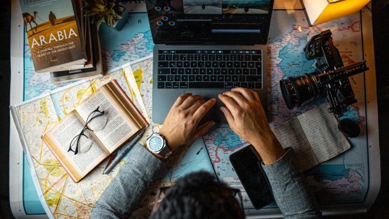 Travel pharmacist contemplating career path with laptop and map, symbolizing flexibility and professional adventure in different locations.